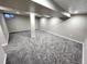 Open basement area with modern gray carpet, freshly painted walls, and ceiling lighting at 3216 S Granby Way, Aurora, CO 80014