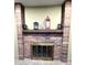Close-up view of the brick fireplace with a wooden mantel and decorative accents at 3216 S Granby Way, Aurora, CO 80014