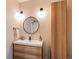 Beautiful bathroom features a wood vanity, round mirror and modern light fixtures at 1902 Pioneer Cir, Lafayette, CO 80026