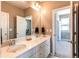 Bathroom featuring double sinks, large mirror and access to another room at 1902 Pioneer Cir, Lafayette, CO 80026