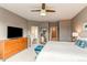 Relaxing main bedroom featuring a ceiling fan, dresser, and easy access to ensuite bathroom at 1902 Pioneer Cir, Lafayette, CO 80026