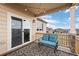 Relaxing back porch with sliding glass door, cozy blue furniture, and decorative outdoor lighting at 2080 Shadow Creek Dr, Castle Rock, CO 80104
