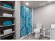 Bathroom features a modern vanity, toilet, blue-patterned shower curtain, and convenient shelving at 2080 Shadow Creek Dr, Castle Rock, CO 80104