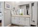 Bathroom with double vanity, framed mirrors, quartz countertops, and walk-in closet access at 2080 Shadow Creek Dr, Castle Rock, CO 80104
