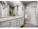 Bathroom with double vanity, framed mirrors, quartz countertops, and glass enclosed shower at 2080 Shadow Creek Dr, Castle Rock, CO 80104