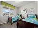 Bright bedroom with two twin beds featuring blue bedding and a window view at 2080 Shadow Creek Dr, Castle Rock, CO 80104
