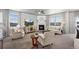 Cozy living room with a fireplace, neutral tones, and lots of natural light through large windows at 2080 Shadow Creek Dr, Castle Rock, CO 80104