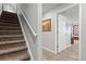 Carpeted stairway leading to a finished basement, featuring a white handrail and a glimpse of the lower level at 2080 Shadow Creek Dr, Castle Rock, CO 80104