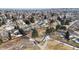 Aerial view of a neighborhood featuring mature trees and a walking path with a bridge over a creek at 11666 W 74Th Way, Arvada, CO 80005