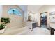 Bright bathroom featuring a soaking tub under a large window with a separate vanity area at 11666 W 74Th Way, Arvada, CO 80005