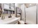Compact bathroom featuring gray cabinets, a shower, and a toilet at 11666 W 74Th Way, Arvada, CO 80005