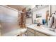 Bathroom with updated shower and vanity and natural stone tile at 11666 W 74Th Way, Arvada, CO 80005