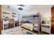 ' bedroom with a bunk bed, desk, and colorful accents, well lit by a modern ceiling fan at 11666 W 74Th Way, Arvada, CO 80005