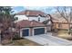 Beautifully landscaped two-story home with an attached three-car garage and a long driveway at 11666 W 74Th Way, Arvada, CO 80005