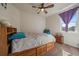 A furnished bedroom with natural light from the window, a ceiling fan, and carpet at 5752 Eldorado Cir, Elizabeth, CO 80107