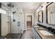 This bathroom showcases a glass-enclosed shower, double vanity with dark countertops, and contemporary lighting at 9094 W 103Rd Ave, Broomfield, CO 80021