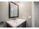 This half-bathroom features a modern vanity with a rectangular sink, dark framed mirror, and neutral wall color at 9094 W 103Rd Ave, Broomfield, CO 80021