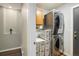 Laundry room with stacked washer and dryer and wire storage racks with wooden cabinets at 9094 W 103Rd Ave, Broomfield, CO 80021