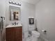Modern half-bathroom featuring a decorative wood vanity, framed mirror, and white tile flooring at 2020 Arapahoe St # 1150, Denver, CO 80205