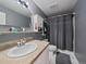 Cozy bathroom featuring a single sink vanity, shower with curtain, and tiled floor at 2020 Arapahoe St # 1150, Denver, CO 80205