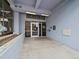 Building entrance with glass doors and a concrete walkway, framed by a blue wall at 2020 Arapahoe St # 1150, Denver, CO 80205