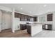 Open kitchen featuring an island, wooden cabinets, stainless steel appliances, and wood floors at 6625 N Nepal St, Aurora, CO 80019