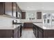 Kitchen featuring an island, stainless steel appliances, wood cabinets, quartz countertops, and wood floors at 6625 N Nepal St, Aurora, CO 80019
