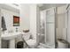 Bathroom featuring a pedestal sink, shower with glass door, toilet and white tile flooring at 8896 W Teton Cir, Littleton, CO 80128