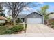 Charming gray home featuring mature landscaping, a two-car garage, and welcoming curb appeal at 8896 W Teton Cir, Littleton, CO 80128