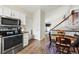 Functional kitchen featuring stainless steel appliances and an open view to dining area and staircase at 8896 W Teton Cir, Littleton, CO 80128