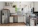 Modern kitchen with stainless steel appliances, bright white cabinets, and stylish countertops overlooking dining area at 8896 W Teton Cir, Littleton, CO 80128