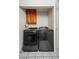 Laundry area featuring modern washer and dryer set with wooden cabinet above at 8896 W Teton Cir, Littleton, CO 80128