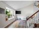Bright living room with hardwood floors, a large window seat, and open staircase to the second floor at 8896 W Teton Cir, Littleton, CO 80128