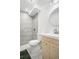Modern bathroom features gray tile shower, light wood vanity, and round mirror at 14441 Maxwell Pl, Denver, CO 80239