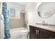 The bathroom has a shower and tub combo, a toilet, dark wooden cabinets, granite countertops, and a round mirror at 14441 Maxwell Pl, Denver, CO 80239