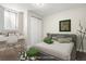 This staged bedroom features neutral colors, comfortable gray headboard, and ample closet space at 14441 Maxwell Pl, Denver, CO 80239