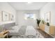 The bedroom is furnished with bed, side table, modern art, rug, house plants, and a bright window at 14441 Maxwell Pl, Denver, CO 80239