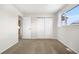 The empty bedroom has neutral paint, carpet floors, baseboard trim, a window, and an air vent at 14441 Maxwell Pl, Denver, CO 80239