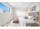 The bedroom is furnished with bed, side table, modern art, rug, and a bright window at 14441 Maxwell Pl, Denver, CO 80239