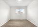 Bright bedroom featuring neutral carpet, a window with white curtains, and freshly painted walls at 14441 Maxwell Pl, Denver, CO 80239