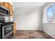 An empty dining area has wood-look floors, neutral paint, a window, and stainless steel appliances at 14441 Maxwell Pl, Denver, CO 80239