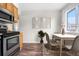 The dining area has a table, chairs, decorative art, indoor plants, wood-look floors, and a window at 14441 Maxwell Pl, Denver, CO 80239
