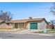 Single-story home with a brick facade, green door, and a single-car garage on a sunny day at 14441 Maxwell Pl, Denver, CO 80239