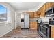 Kitchen with stainless steel appliances, wood cabinets, and modern countertops at 14441 Maxwell Pl, Denver, CO 80239