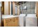 Laundry room features new washer/dryer, storage cabinets, and unfinished walls and ceiling at 14441 Maxwell Pl, Denver, CO 80239