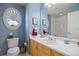 A blue themed bathroom with a sink and oval window at 4373 E Phillips Pl, Centennial, CO 80122
