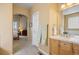 Bright bathroom featuring a large vanity, a separate toilet room, and an arched entry to the bedroom at 4373 E Phillips Pl, Centennial, CO 80122