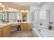 Bright bathroom with a soaking tub, glass enclosed shower, and double sink vanity at 4373 E Phillips Pl, Centennial, CO 80122