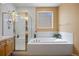 A well-lit bathroom with a glass shower, tile flooring, and soaking tub at 4373 E Phillips Pl, Centennial, CO 80122