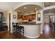 A kitchen features granite countertops, wooden cabinetry, and bar stool seating at the island at 4373 E Phillips Pl, Centennial, CO 80122